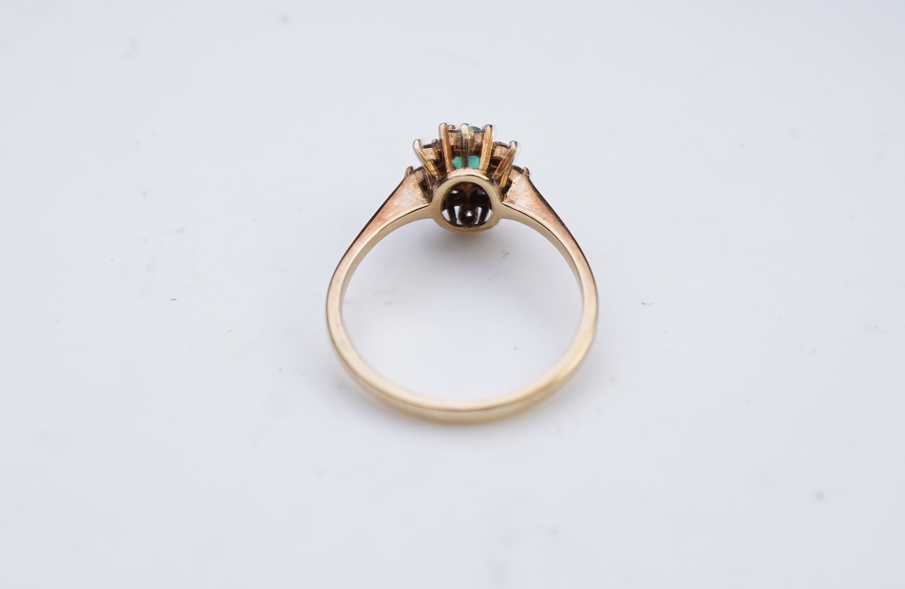 An emerald and diamond cluster ring